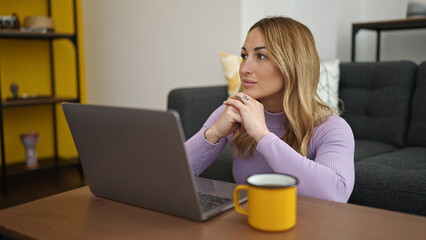 Poster - Young beautiful hispanic woman using laptop drinking coffee at home