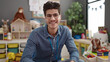 © Krakenimages.com - Young hispanic man preschool teacher smiling confident sitting on table at kindergarten