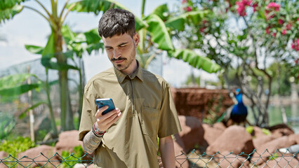 Sticker - Young hispanic man using smartphone smiling at park