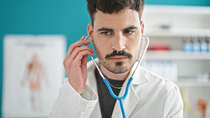 Sticker - Young hispanic man doctor examining with stethoscope at clinic