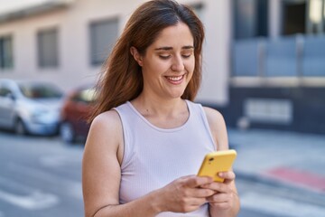 Sticker - Young woman smiling confident using smartphone at street