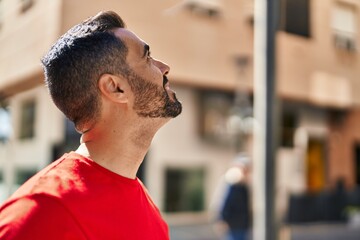 Sticker - Young hispanic man smiling confident looking to the sky at street