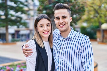 Wall Mural - Man and woman couple smiling confident hugging each other at park