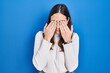 © Krakenimages.com - Young hispanic woman standing over blue background rubbing eyes for fatigue and headache, sleepy and tired expression. vision problem