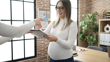 Wall Mural - Young pregnant woman business worker singing contract at office