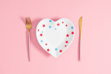 Wall Mural - 4th of July, USA Presidents Day, Independence Day, US election concept. Flat lay top view of heart shaped plate, knife fork, gift box heart on pastel pink background  with space for text or promotion 