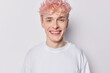 © WHstudio Leushin N - Portrait of handsome pink haired man dressed in casual clothes smiles gladfully concentrated into camera expresses positive emotions isolated over white background. People and face expressions concept