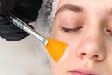 Fototapeta  - Cosmetologist doctor making anti-age procedure apply peeling acid. Beautician specialist doing skincare treatment in the beauty salon