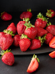 Wall Mural - Ripe red strawberries on a black table