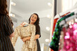 © New Africa - Beautiful young woman with golden sequin dress near mirror in boutique. Choosing party clothes