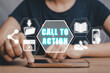 © Satori Studio - Call to action concept, Person hand touching on smart phone  with call to action icon on virtual screen.