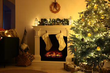 Poster - Stylish fireplace near decorated Christmas tree and accessories in cosy room