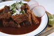 © Elmer Hidalgo Photo - A plate of beef birria tacos with a red sauce and radishes