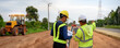 Asian surveyor engineer two people checking level of soil with Telescope equipment to measure leveling for cut and fill at the highway road construction site. Banner size with copy space.
