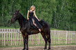Cute girl with long hair riding a horse outdoors, a beautiful frame with a horse
