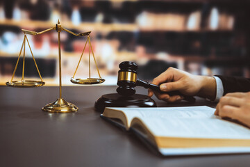 Wall Mural - Closeup lawyer or attorney preparing for lawsuit or litigation, reading or studying on legal book on his desk at library for educational law school concept, decorated with legal symbols. Equilibrium