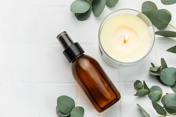 bottle of natural cosmetic oil, aroma candle and eucalyptus leaves