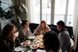 © Drobot Dean - Group of cheerful friends talking while dining in restaurant