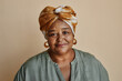 Waist up portrait of kind black senior woman looking at camera and wearing headscarf