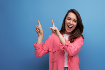 Wall Mural - positive emotional black-haired woman in casual style announces discounts on studio background