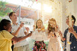 © DragonImages - Group of excited friends dancing under falling confetti at home birthday party