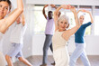 © JackF - Group of people of different ages repeats active movements of modern dance after young girl instructor. Active longevity, physical activity