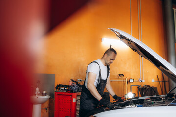 Auto car repair service center. Mechanic examining car engine.