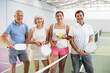 © JackF - Group of happy smiling men and women of different ages in sportswear with rackets and balls in hands posing near net