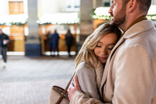 Young Woman Hugging Man At Christmas Market