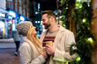 © Westend61 - Happy couple standing with coffee cup at Christmas market