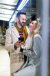 © Westend61 - Happy man and woman standing with mobile phone
