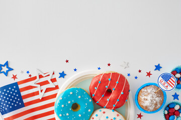 Dessert-centered festivity on July 4th idea. Top view flat lay of donuts on the plate, cupcake, colorful candies, national flag, stars on white background with empty space for advert or text