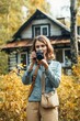 © Road Red Runner - Evocative vertical photo of a young woman in front of her detached house in the woods.