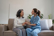 © Natee Meepian - caregiver with senior woman and holding hands for care indoors. Retirement, consulting and professional female nurse with elderly person smiling together for healthcare support at nursing home