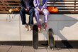 © Johnér - Low section of two women sitting near skateboards