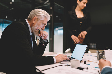 Sticker - Elderly businessman using computer during business meeting