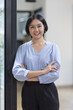 © David - Young asian woman, professional entrepreneur standing in office clothing, smiling and looking confident, workplace office background