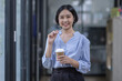 © David - Young asian woman, professional entrepreneur standing in office clothing, smiling and looking confident, workplace office background
