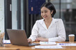 © David - Asian Businesswoman Using laptop computer and working at office with calculator document on desk, doing planning analyzing the financial report, business plan investment, finance analysis concept.