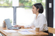 © David - Asian Businesswoman Using laptop computer and working at office with calculator document on desk, doing planning analyzing the financial report, business plan investment, finance analysis concept.