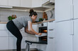 © Johnér - Pregnant woman putting dish in oven