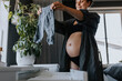 © Johnér - Pregnant woman organizing baby clothes and getting ready for baby arrival