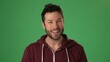 © Robert Peak - Smiling confident young teacher man professional looking at camera on green screen chroma key. Happy smiling millennial businessman, student, worker, close up face portrait. Concept remote learning.
