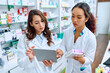 © Drazen - Female pharmacists cooperate while using touchpad and working in drugstore.