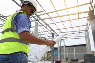 Construction engineers  wear reflection green vest work on site   by following up with the planned design.building contractor check the work against the construction plan.