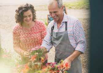 Canvas Print - Plant nursery worker helping woman with flowers