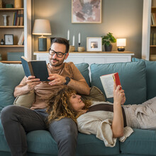 Man And Woman Caucasian Adult Couple Read Books At Home On Sofa Bed