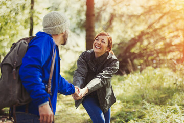 Wall Mural - Smiling couple holding hands hiking in woods