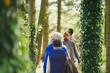 Canvas Print - Friends hiking among ivy covered trees in woods