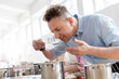 © KOTO - Man smelling food leaning over pot in cooking class kitchen